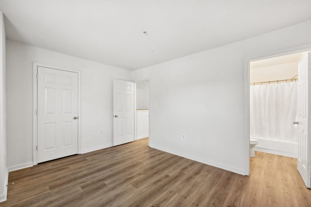 an empty living room with white walls and wood floors